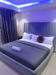 um quarto com uma cama grande e iluminação azul em THE HAVEN SUITE em Lagos