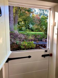a door with a window with a garden outside at The Georgian Coach House:New Forest with hot tub in Fordingbridge