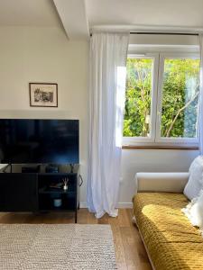 a bedroom with a bed and a tv and a window at Le Pistachier - Maison cozy avec jardin privatif in Saint-Jean-de-Védas