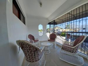 a room with chairs and a table and a large window at Santiago City Center Huge nice Apartment to stay rooftop to enjoy the city view in Santiago de los Caballeros