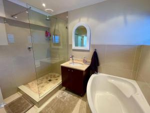 a bathroom with a tub and a sink and a shower at Perfect location #19, Mouille Point in Cape Town