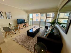 a living room with a couch and a table at Ideal location, Mouille Point in Cape Town