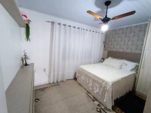 una camera con letto e ventilatore a soffitto di Casa com piscina em Torres/RS a Torres