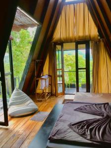 The Backyard Balangoda في بالانجودا: غرفة بسرير في خيمة مع نوافذ