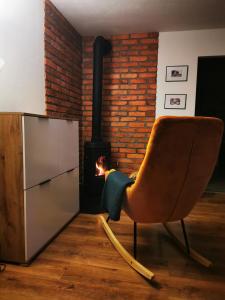 uma cadeira num quarto com um fogão a lenha em Apartament Chełmsko Śląskie em Chełmsko Śląskie