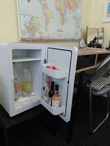 a white refrigerator with its door open next to a desk at STUDIO PAD in Cardiff