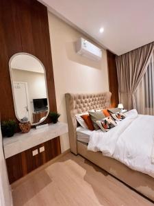 a bedroom with a large bed and a mirror at شقة فندقية لاكجري مع بلكونة الملقا in Riyadh