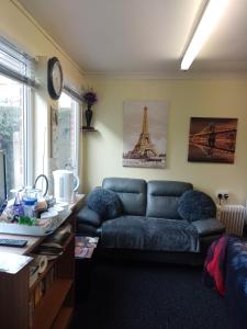 a living room with a couch and a clock on the wall at STUDIO PAD in Cardiff