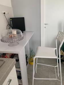 escritorio blanco con silla blanca y ordenador en Camera con bagno privato, en Ragalna