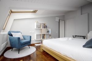 a bedroom with a bed and a blue chair at Double Luxury Exclusive Suite-Duomo in 12 Minutes in Milan