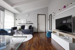 een woonkamer met een bank en een tv bij Double Luxury Exclusive Suite-Duomo in 12 Minutes in Milaan
