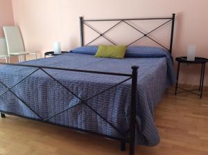 a bedroom with a bed with a blue comforter at A un passo da... B&B in Elmas