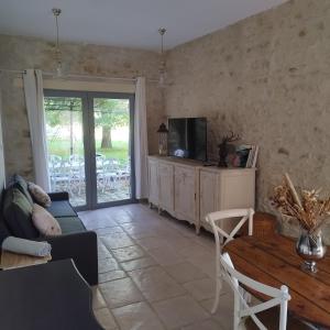 a living room with a couch and a table at Grande suite en duplex avec 2 chambres, terrasse dans corps de ferme in Villiers-sous-Grez