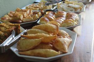 a table with several plates of pastries and other desserts at Pousada Encantos de Arraial in Arraial d'Ajuda