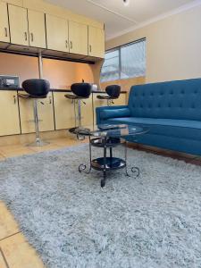a living room with a blue couch and a rug at Apartment on Liddiard in East London