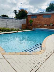 a swimming pool in front of a brick building at Apartment on Liddiard in East London