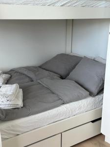 una cama con almohadas grises encima en Snäckbacken, en Visby