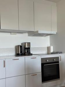 a kitchen with white cabinets and a stove top oven at Snäckbacken in Visby