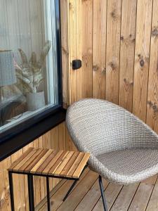 a wicker chair and a bench on a porch at Snäckbacken in Visby