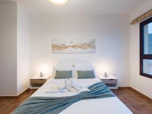 a bedroom with a white bed and two tables at Giraud II - Beachfront - Pool - 46 m2 Terrace in Santa Maria de Guia de Gran Canaria