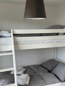 a white bunk bed with a ladder and a lamp at Snäckbacken in Visby