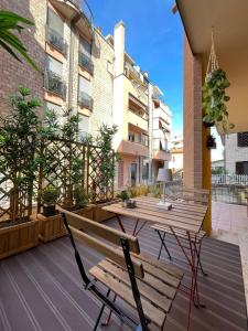 a patio with a wooden table and a bench and a table at Appartamento Montebello in Terni