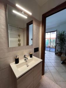 bagno con lavandino bianco e specchio di Appartamento Montebello a Terni
