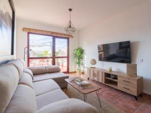 sala de estar con sofá y TV en Giraud II - Secluded beachfront duplex, en Santa María de Guía de Gran Canaria