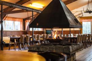 a fire pit in a restaurant with tables and chairs at Groepsaccommodatie - De Ooymanhoeve in Doetinchem