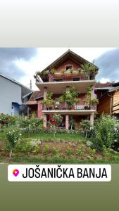 a building with a balcony with plants on it at Apartman Jovanović in Jošanička Banja +6 photos