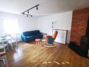 uma sala de estar com um sofá azul e uma mesa em Apartament Chełmsko Śląskie em Chełmsko Śląskie