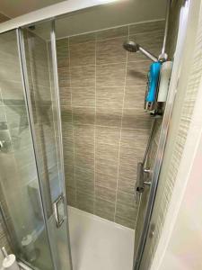 y baño con ducha y puerta de cristal. en 3 bedroom house - Hampton Water, en Peterborough