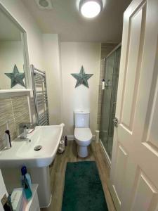 Baño con aseo y 2 estrellas en la pared en 3 bedroom house - Hampton Water, en Peterborough