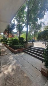 a sidewalk with stairs and trees in a park at RentAdore Retiro Studio in Madrid