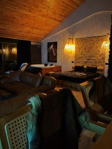 ein Wohnzimmer mit einem Sofa und einer Steinmauer in der Unterkunft Çatı Katı Bungalow & Dome in Çivril