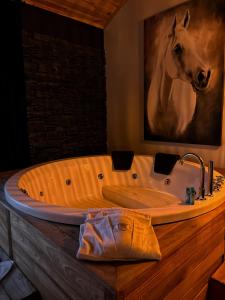 a wooden bath tub with a horse painting on the wall at Çatı Katı Bungalow & Dome in Çivril