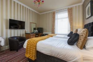 a hotel room with a bed and a flat screen tv at Adelaide Lodge - Town Centre - Opposite Winter Gardens in Blackpool