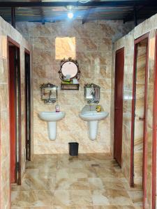a bathroom with two sinks in a stone wall at Sunset Dreams camp in Wadi Rum