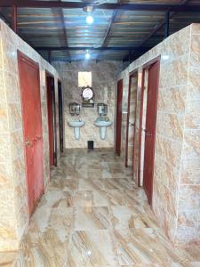Baño con 2 lavabos en una pared de piedra en Sunset Dreams camp en Wadi Rum