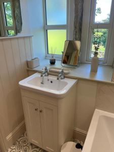 y baño con lavabo y espejo. en Bents Holiday Cottage en Oxenhope