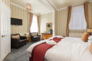 a hotel room with a large bed and a chair at Adelaide Lodge - Town Centre - Opposite Winter Gardens in Blackpool