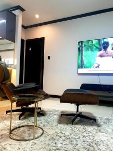 sala de estar con 2 sillas y pantalla en 2Bedroom Luxury hotel apartment Fourways en Johannesburgo
