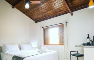 Habitación blanca con cama y ventana en Chalé Mantiqueira, en Cunha