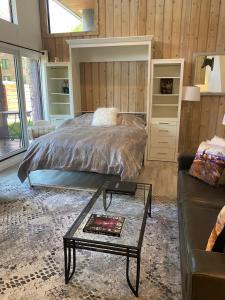 ein Schlafzimmer mit einem Bett, einem Tisch und einem Sofa in der Unterkunft Cooper Street Loft by Snowmass Vacations in Aspen