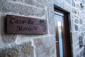 ein Schild an der Seite eines Steingebäudes in der Unterkunft A CASA DA MOREIRA - Casa rural en Ponte Maceira in A Coruña