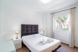 - une chambre avec un grand lit blanc et 2 serviettes dans l'établissement Rubarsal Burriana 1J Casasol, à Nerja