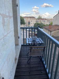 una mesa y una silla en un balcón con vistas en T2 PARFAITEMENT SITUÉ AU PIED DE LA CATHÉDRALE, en Périgueux