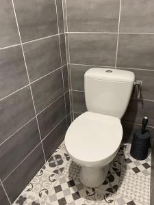 La salle de bains est pourvue de toilettes blanches et d'un mur carrelé. dans l'établissement T2 PARFAITEMENT SITUÉ AU PIED DE LA CATHÉDRALE, à Périgueux