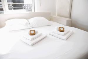Una cama blanca con dos toallas y dos cajas. en Lovely Modern 1 BR apartment en Luxemburgo