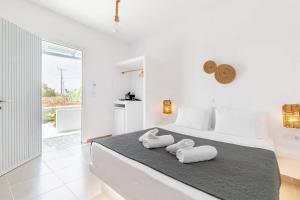 a white bedroom with two towels on a bed at Naxos Beachwalk Rooms in Naxos Chora